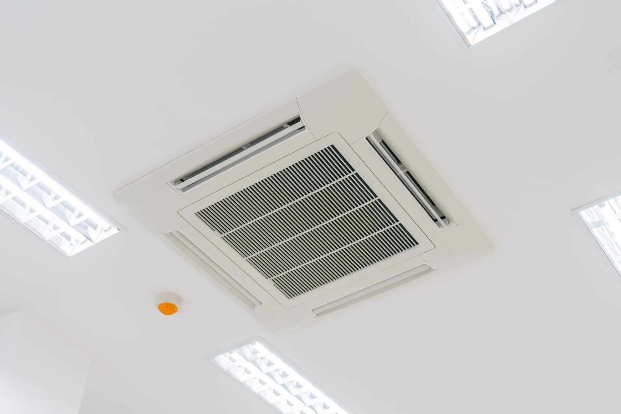 Office air conditioning system on ceiling with 4 lights surrounding it