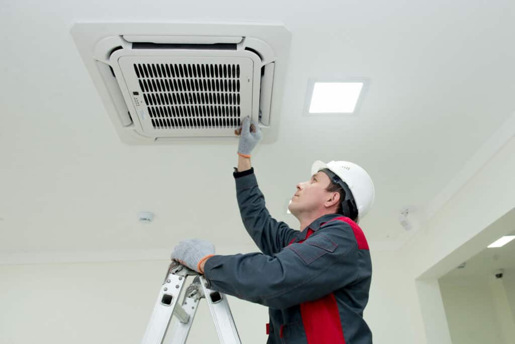 Engineer installing an air conditioning system in an office